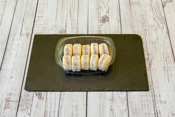 A portion of mini Argentine alfajores inside a transparent plastic container for home delivery