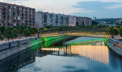 Metal walkway over the manzanares river at sunset in the city of Madrid