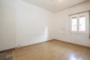 Obraz premium Empty room with poorly installed oak flooring white aluminum window and dirty white walls