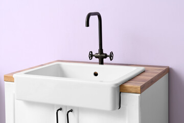 Table with ceramic sink near lilac wall