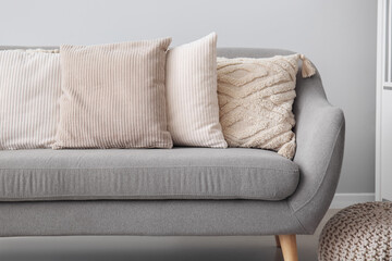 Stylish pillows on grey sofa in living room