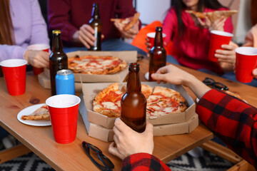 Group of friends with tasty pizza and drinks at home, closeup