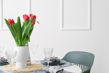 Table setting for International Women's Day celebration with tulip flowers in light room