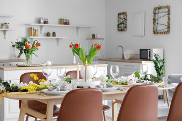 Beautiful table setting for International Women's Day celebration with different flowers in interior of light room