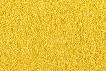 Dried yellow couscous grain background