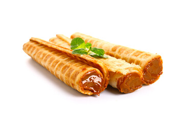 Delicious wafer rolls with boiled condensed milk and mint isolated on white background