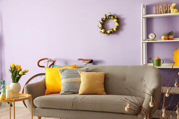 Interior of living room with Easter wreath and grey sofa