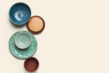 Composition with clean ceramic plates and bowls on white background