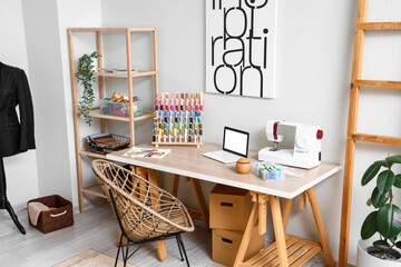 Interior of modern atelier with tailor's workplace and shelving unit