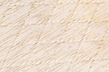 Fototapeta premium Elegant cream fabric texture with golden threads and diagonal weave pattern, textile background for design and decor
