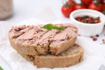 Delicious liverwurst sandwich with basil on white table, closeup