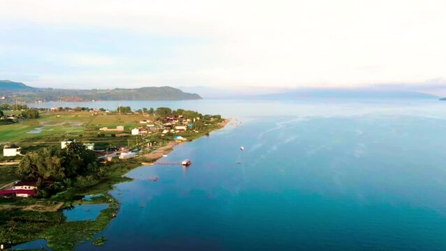 Aerial view of the beautiful Balige City, Toba, North Sumatera at sunrise bordering the toba lake. View of Lake Toba which is one of the UNESCO Global Geopark. 