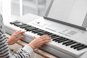 Fototapeta na wymiar Female musician playing synthesizer, closeup