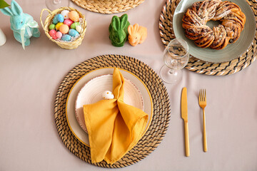 Plate with folded napkin and cutlery on table served for Easter celebration