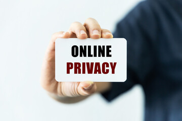 Online privacy text on blank business card being held by a woman's hand with blurred background. Business concept about online privacy.
