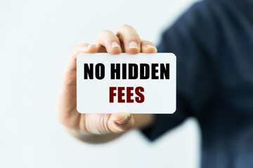 No hidden fees text on blank business card being held by a woman's hand with blurred background. Business concept about no hidden fees.