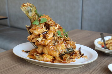 Thai style seafood, Deep Fried Seabass Fish with  Sweet-Sour Tamarind Sauce recipe on white plate.