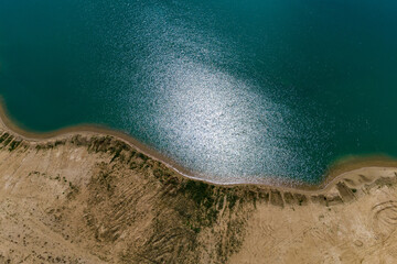 The coastline of a reservoir with bluish water, aerial view