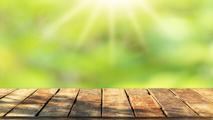 Wooden table top with natural green blurred background or various leaves, fresh bright sunlight, product empty concept.