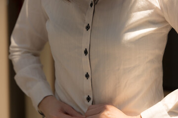 シャツのボタンをはめている女性　手　上半身　着替え　イメージ