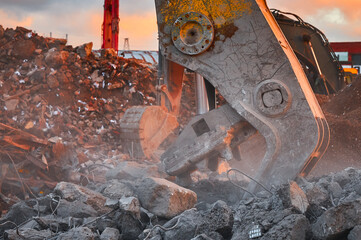 Metal crusher on excavator rigging destroys armored concrete