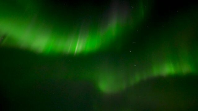 Fast moving green colored aurora Borealis at dark sky over Iceland Island at night - Handheld bottom up