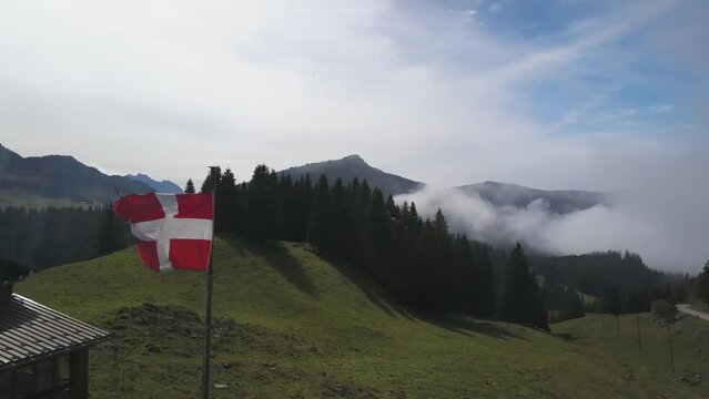 Flag of Savoy waving in the wind in mountain landscape, Haute Savoie in France. Aerial orbiting and sky for copy space