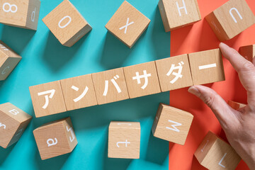 アンバサダーと書かれたブロックと手
