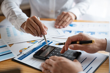 Investment finance concept, group of business people pointing to the graph Strategic Meetings and Brainstorming calculate with calculator Analysis of finance and marketing of new business projects.