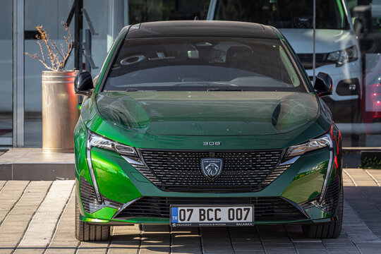 Side; Turkey &ndash; February 18 2023:     green  new  Peugeot 308    is parked  on the street on a warm day against the backdrop of a  autosalon