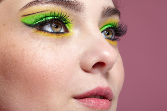 Closeup shot of human female face with green makeup.