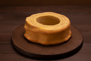 Lithuanian, Polish, German spit cake sakotis, baumkuchen, sekacz on wooden table. Delicious homemade traditional cake. Low key photo, horizontal plane.