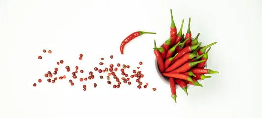 Gordijnen Flat lay composition with fresh chili peppers in bowl and dry pink peppercorns seeds on white background. Banner, top view. © elcovalana