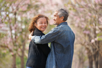 Fototapeta premium portrait romantic asian senior couple walking,talking in nature on springtime,a woman facing to camera,concept for elderly lifestyle,relaxing,exploring,travelling,well being,health benefits in nature