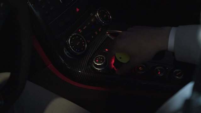 Driver in suit touching the buttons in the vehicle.