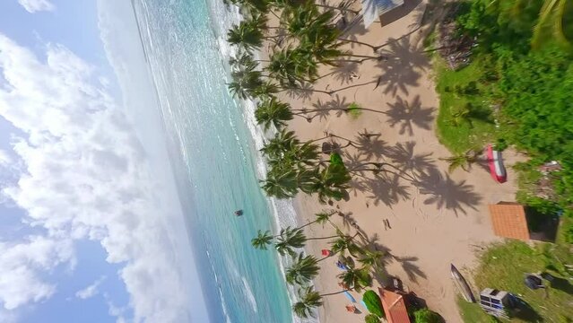 Fpv flight over palm trees, golden beach and Caribbean sea with anchored ship during sunny day - PLAYA LOS COQUITOS, MARIA TRINIDAD SANCHEZ