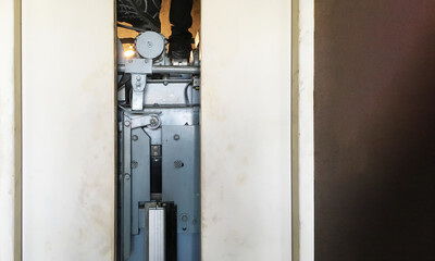 Image of elevator doors open for lift machinist technician inspector to service maintenance checking fixing and adjusting in elevator shaft with motor driven machine for technology background.