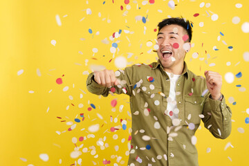 Happy chinese man surrounded by confetti flying in the air