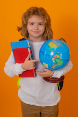 Fototapeta premium School children. School kid hold world globe and book. Back to school. Funny little student boy from elementary school with book. Pupil on studio isolated background.