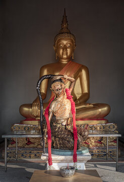 Shrine of the Golden Buddha Statue in meditative posture and the Statue of Phra Mae Thorani goddess or Vasundhara or Dharani angel deity at the Thai temple. Space for text.