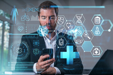 Smiling businessman talking holding using smartphone typing at office workplace with notebook. Concept of distant work, business education. Buy medical healthcare insurance