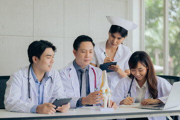 Group of orthopaedic professional doctor working researching or learning knee bone model at hospital