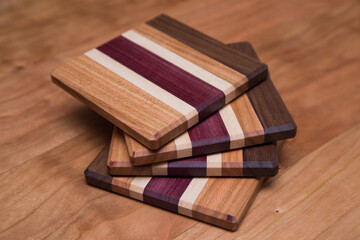 Set of four hardwood coasters with different layers of maple, walnut, purple heart and cherry