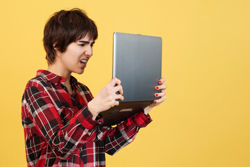 Worried androgynous person standing while using a laptop