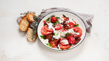 Delicious caprese salad with tomatoes and mozzarella cheese with fresh leaves. Italian food.