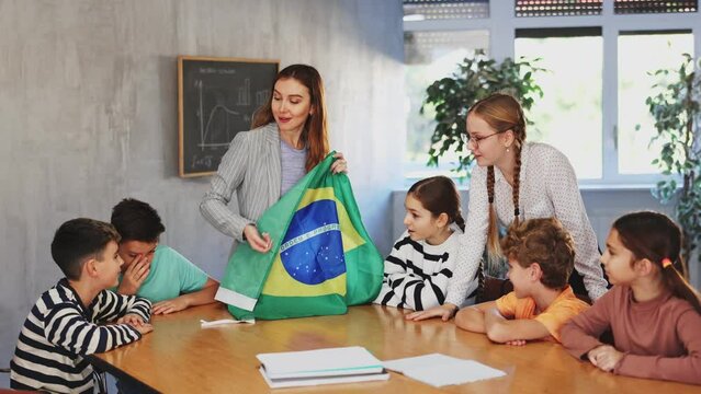 Teacher holds the flag of Brazil in her hands and tells the students about this country. High quality 4k footage