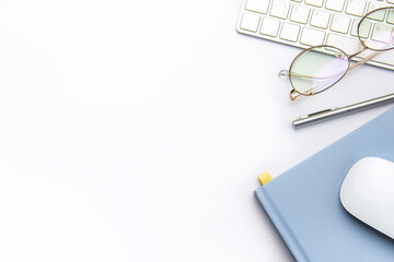 Keyboard, computer mouse and notebook with pen on white office desk