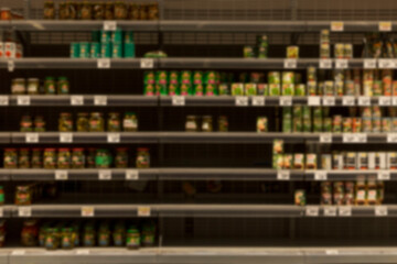 Half-empty shelves with canned food in the store. Panic and crisis. Blurred. Front view.
