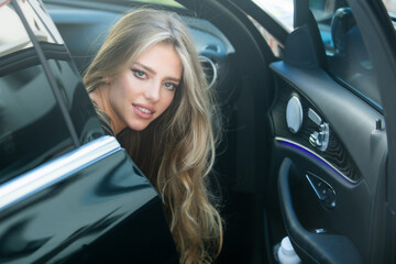 Fototapeta na wymiar Beautiful young woman in car. Stylish young lady in elegant clothes.