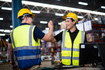 Two Asian warehouse workers showing teamwork and partnership. teamwork at warehouse storage department.